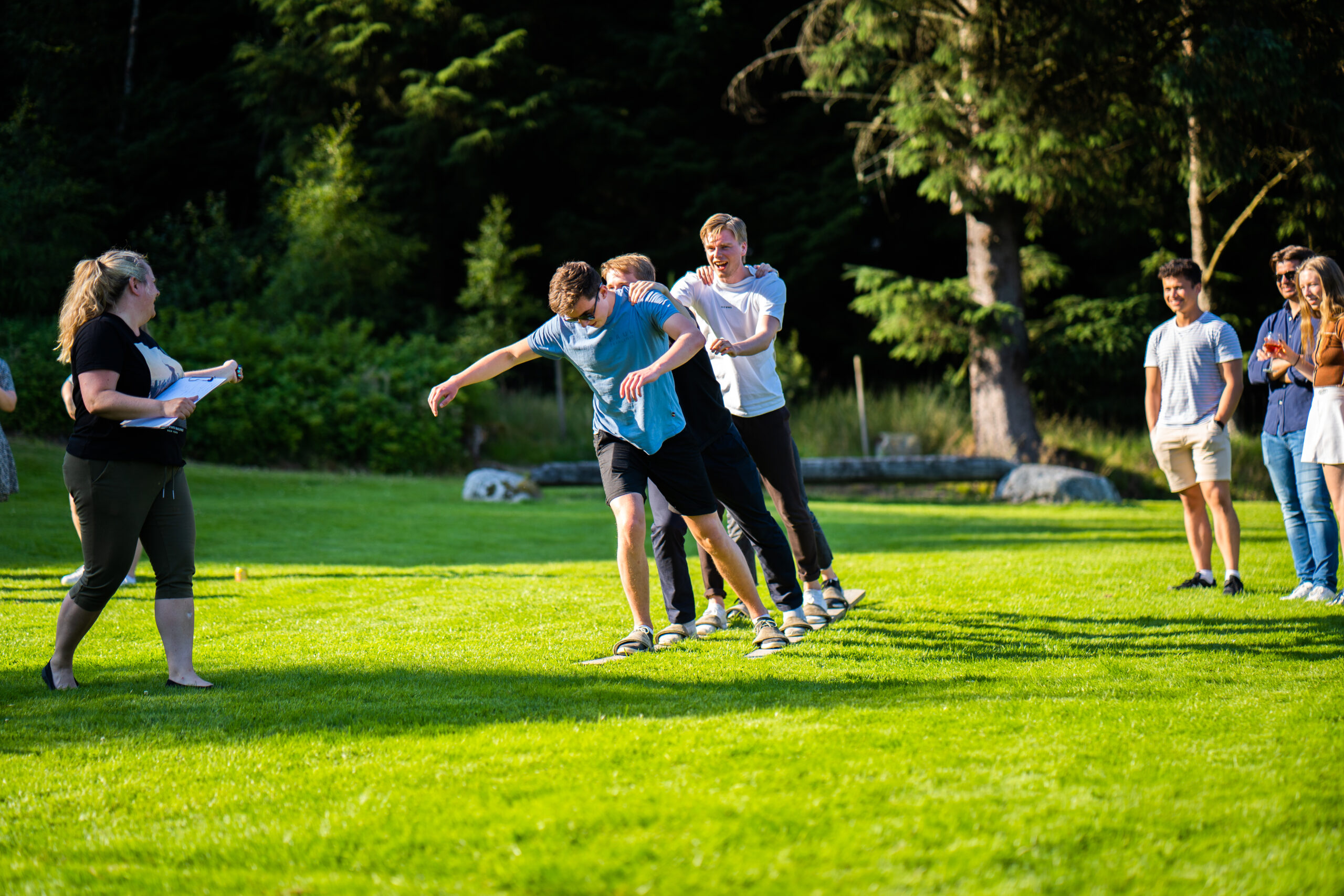 Unge folk som konkurrerer ute på en gressplen i solen