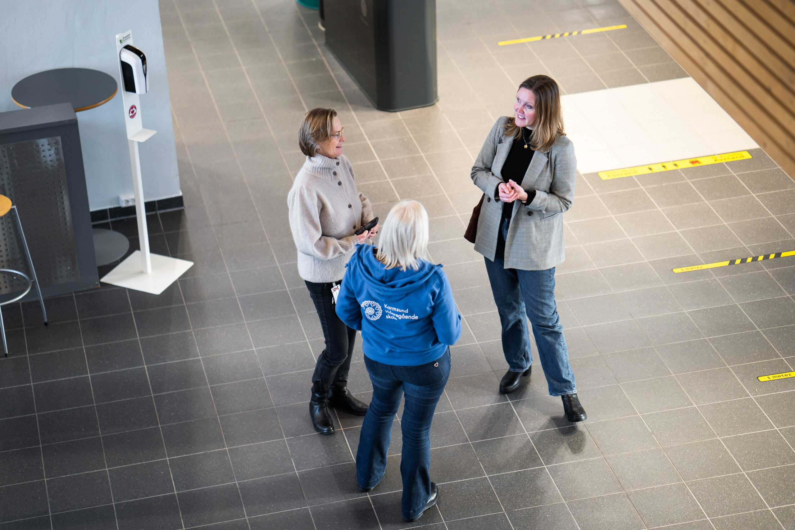 Bilde av tre damer som prater i en gang på en videregående skole